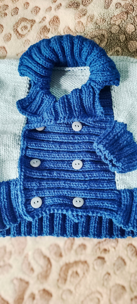 
                  
                    Handknitted baby reefer jacket for 6-12 months, unisex, in two shades of blue with wide collar and buttons, made from 100% acrylic yarn for warmth.
                  
                