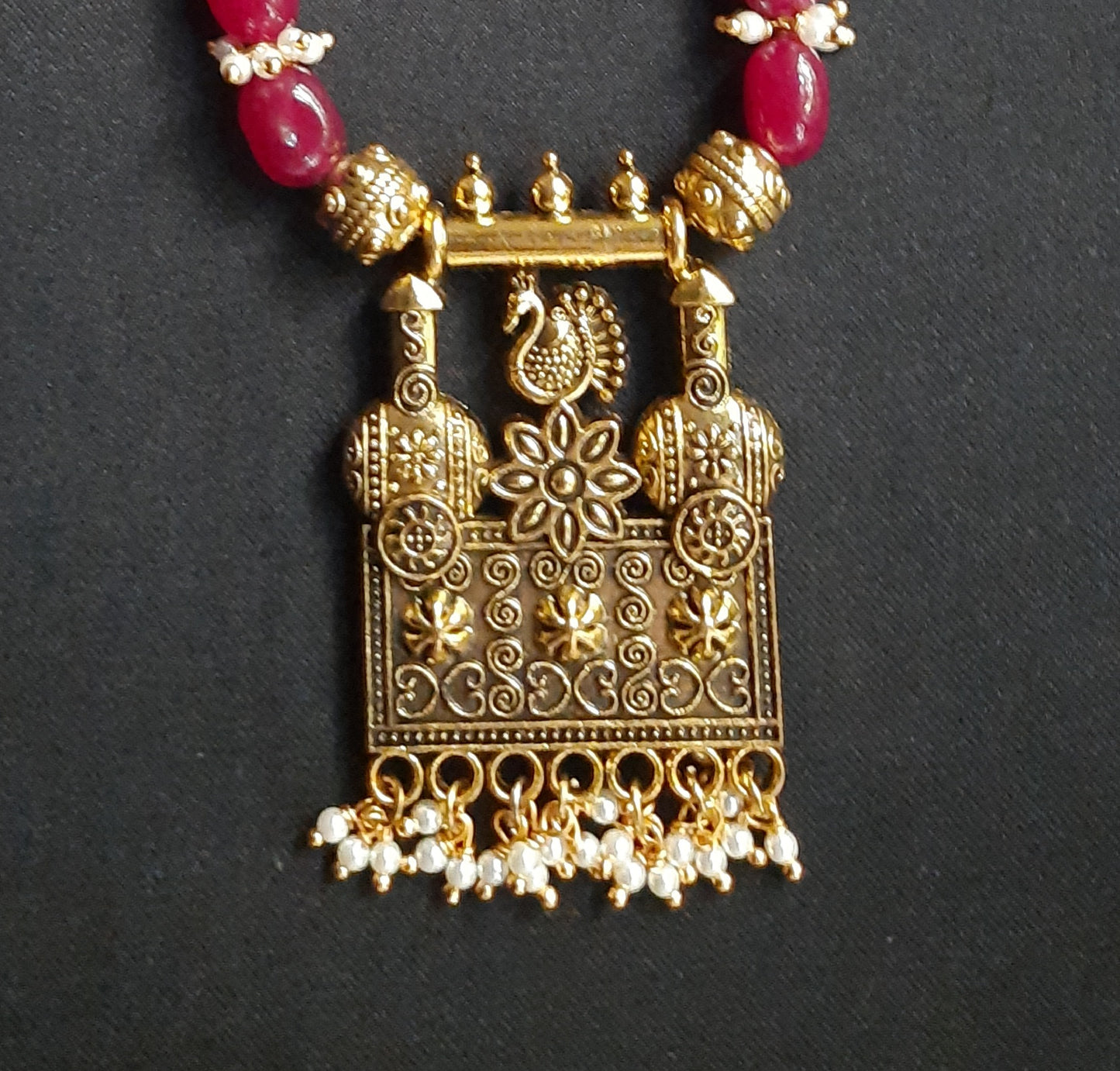 
                  
                    Gorgeous ruby red Dul Dul agate beads necklace with peacock pendant and matching peacock earrings.
                  
                