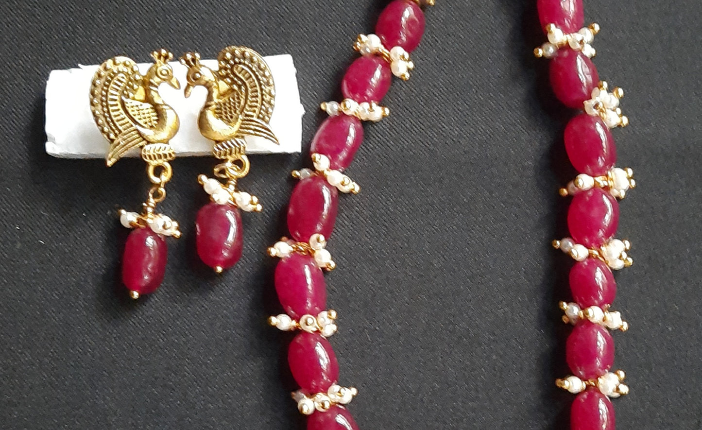 
                  
                    Gorgeous ruby red Dul Dul agate beads necklace with peacock pendant and matching peacock earrings.
                  
                