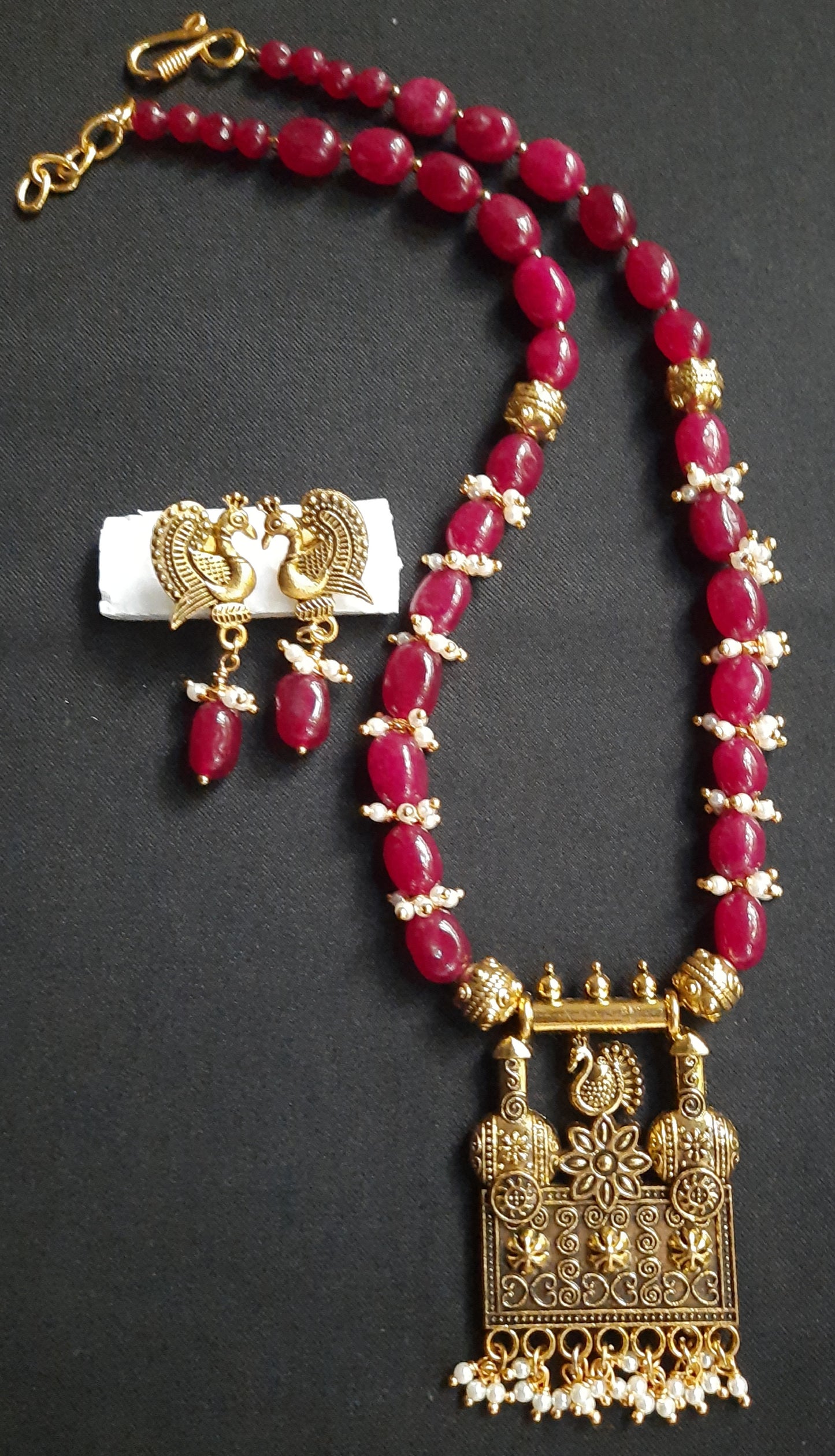 
                  
                    Gorgeous ruby red Dul Dul agate beads necklace with peacock pendant and matching peacock earrings.
                  
                