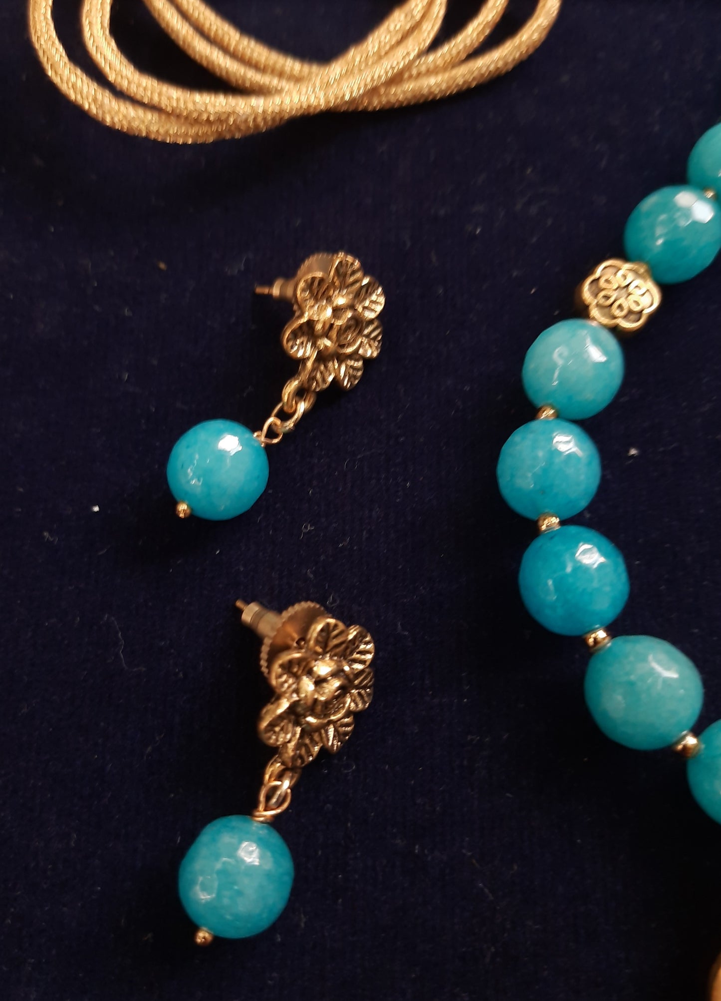 
                  
                    Pretty blue semiprecious agate beads neckwear with golden pendant and matching earrings
                  
                
