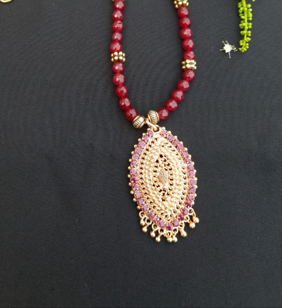 
                  
                    Red agate beads necklace with oxidised gold pendant with red stones.
                  
                