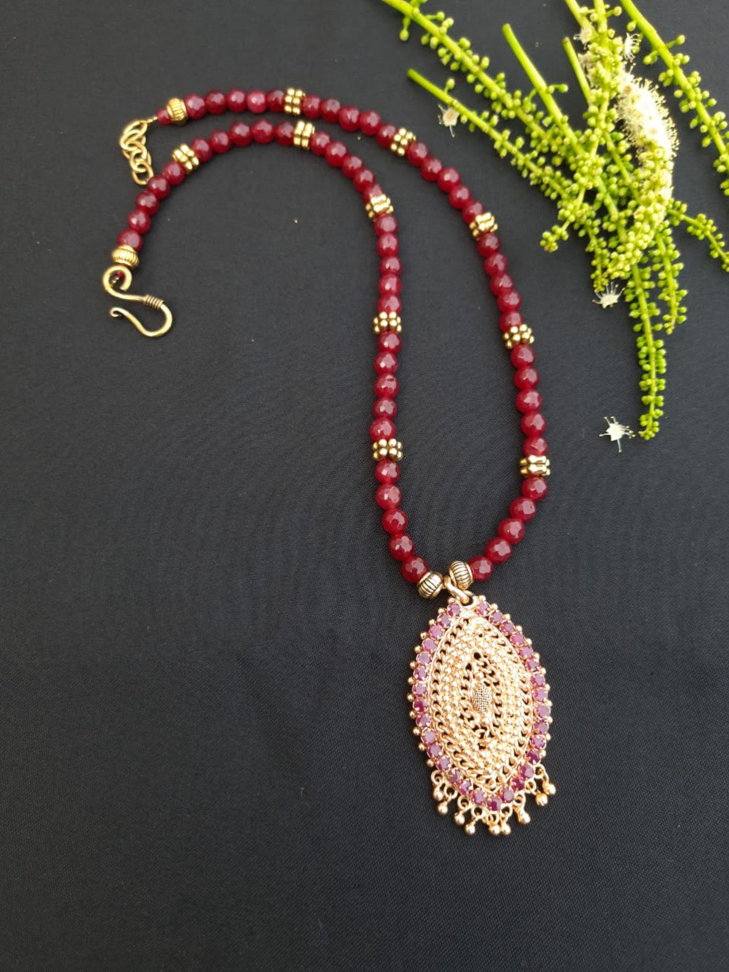 
                  
                    Red agate beads necklace with oxidised gold pendant with red stones.
                  
                